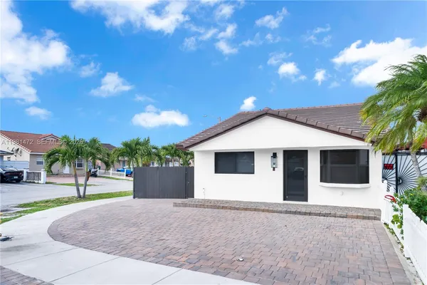 a white house with a tree in front of it