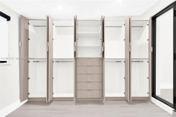 a view of walk in closet with empty racks
