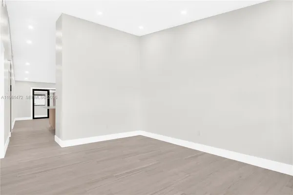a view of an empty room with wooden floor