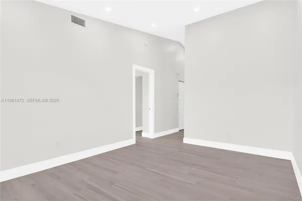a view of an empty room with wooden floor