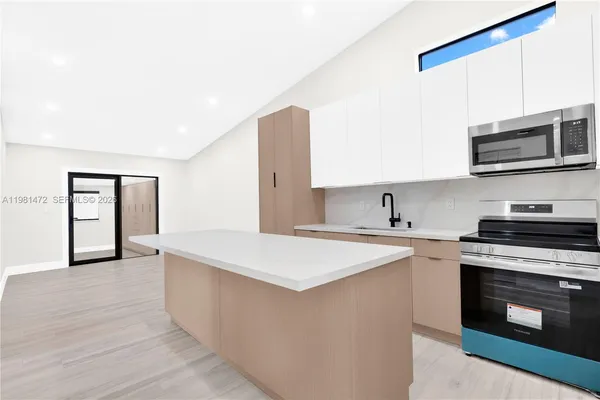 a kitchen with stainless steel appliances a stove microwave and sink