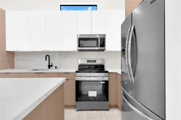 a kitchen with stainless steel appliances a stove microwave and sink
