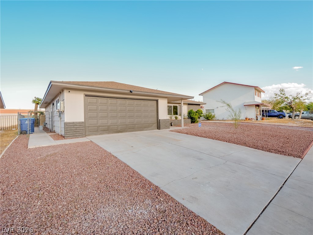 321 Lakehurst Road Las Vegas, NV 89145 - Photo 3 of 33 An attached two-car garage sits at the end of a wide concrete driveway.