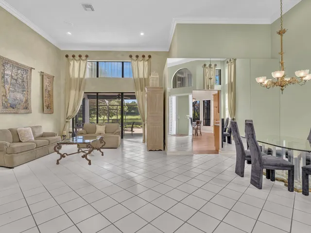 a living room with furniture a dining table and a chandelier