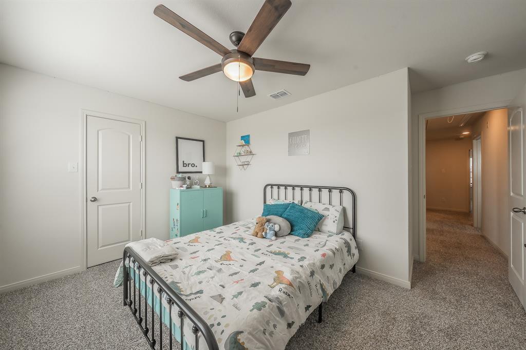 8125 White Sulphur Road Ponder, TX 76259 - Photo 30 of 38 Interior room featuring light gray wall paint, carpeting, a ceiling fan with light fixture, and a paneled door with a round knob