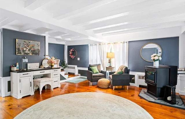 a living room with furniture a large window and dining table