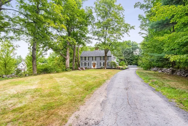 a view of house with yard outdoor seating and trees