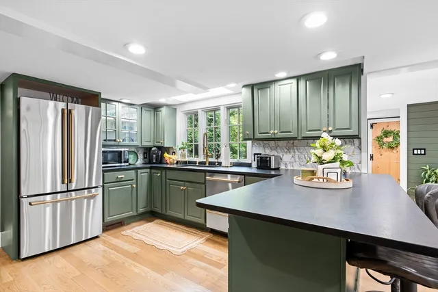 a kitchen with stainless steel appliances granite countertop a sink stove and refrigerator