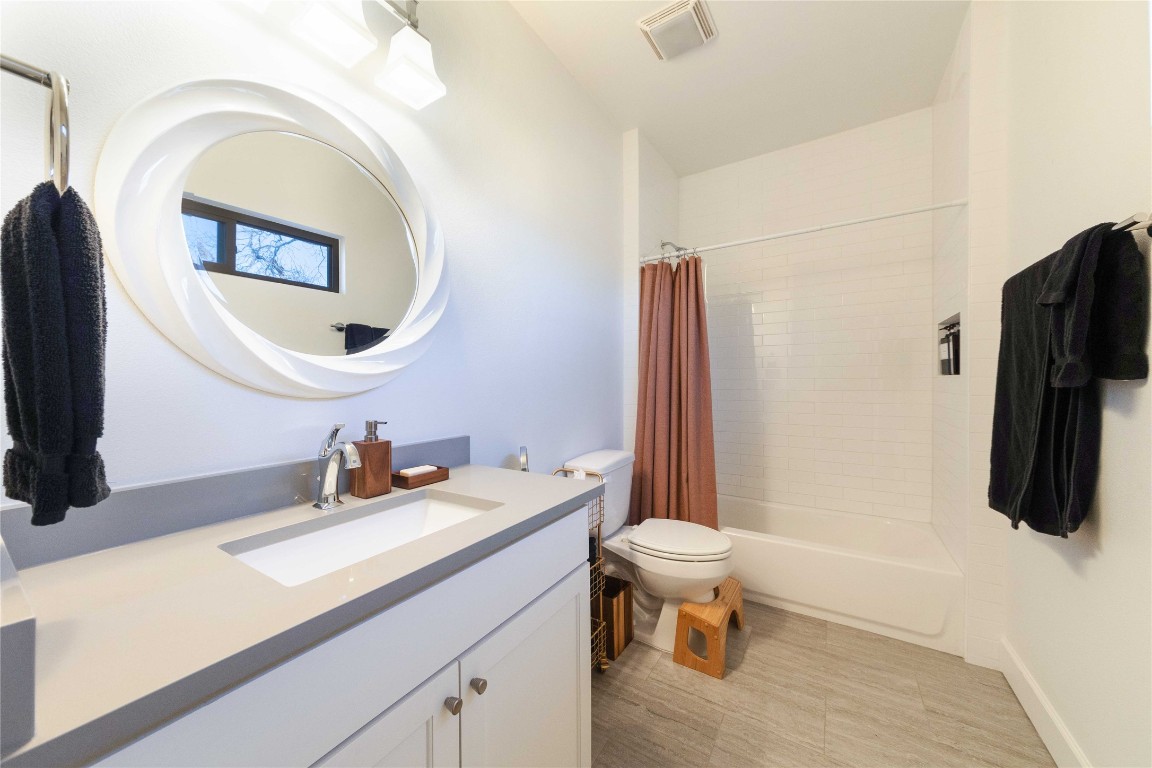 4704 Duval Street Austin, TX 78751 - Photo 17 of 29 Full bathroom featuring visible vents, shower / tub combo with curtain, vanity, and toilet