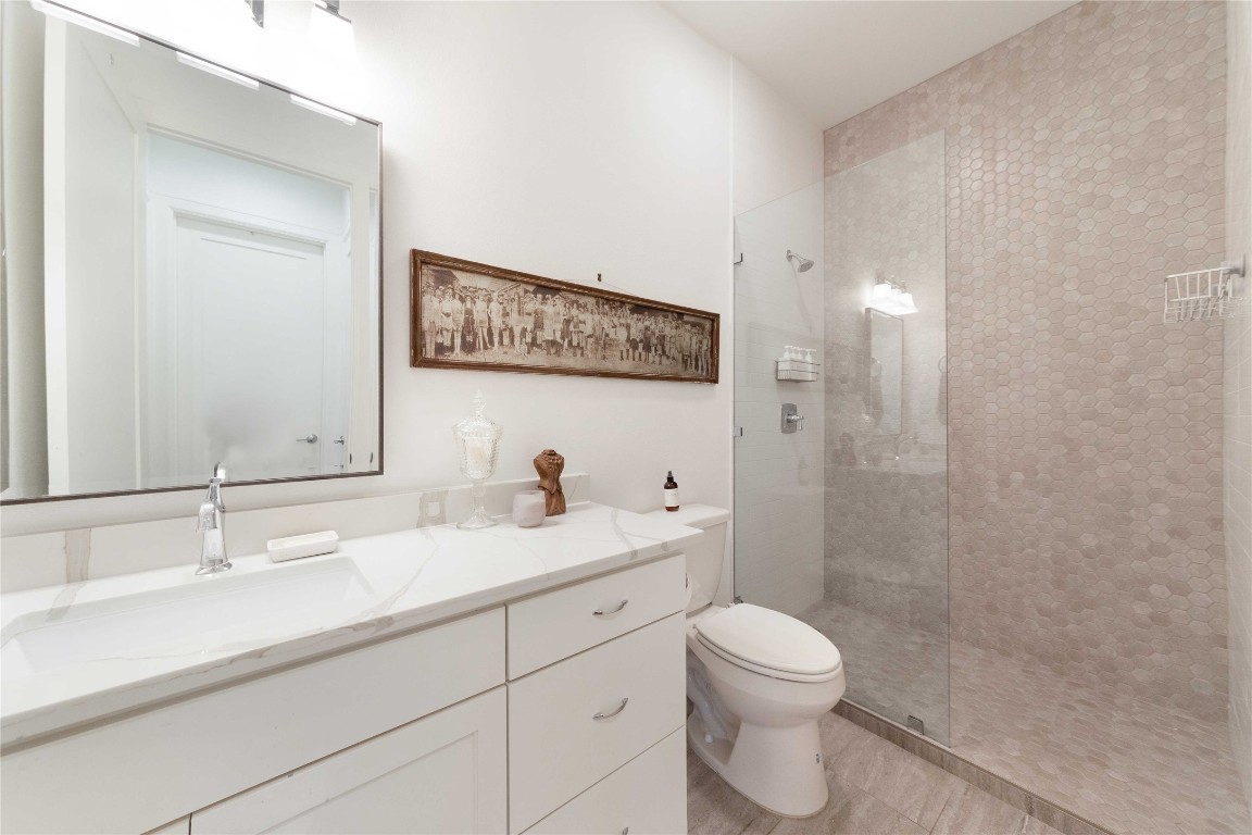 4704 Duval Street Austin, TX 78751 - Photo 19 of 29 Full bath with toilet, a walk in shower, and vanity