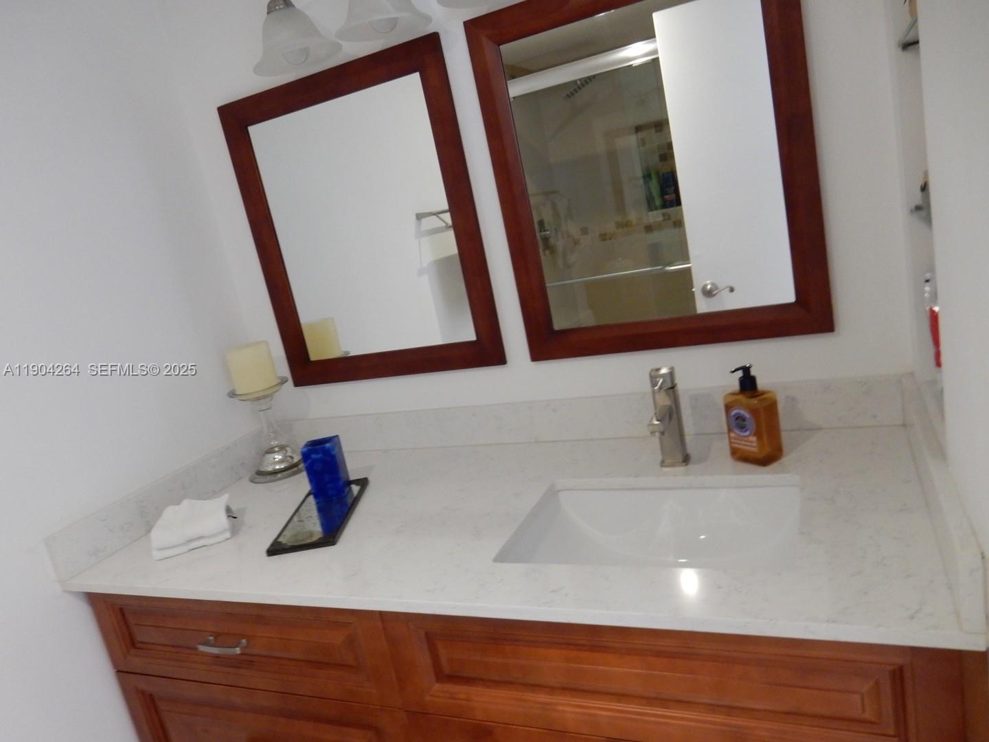 1420 Brickell Bay Drive, Unit 1406D Miami, FL 33131 - Photo 11 of 23 a bathroom with a sink and a mirror