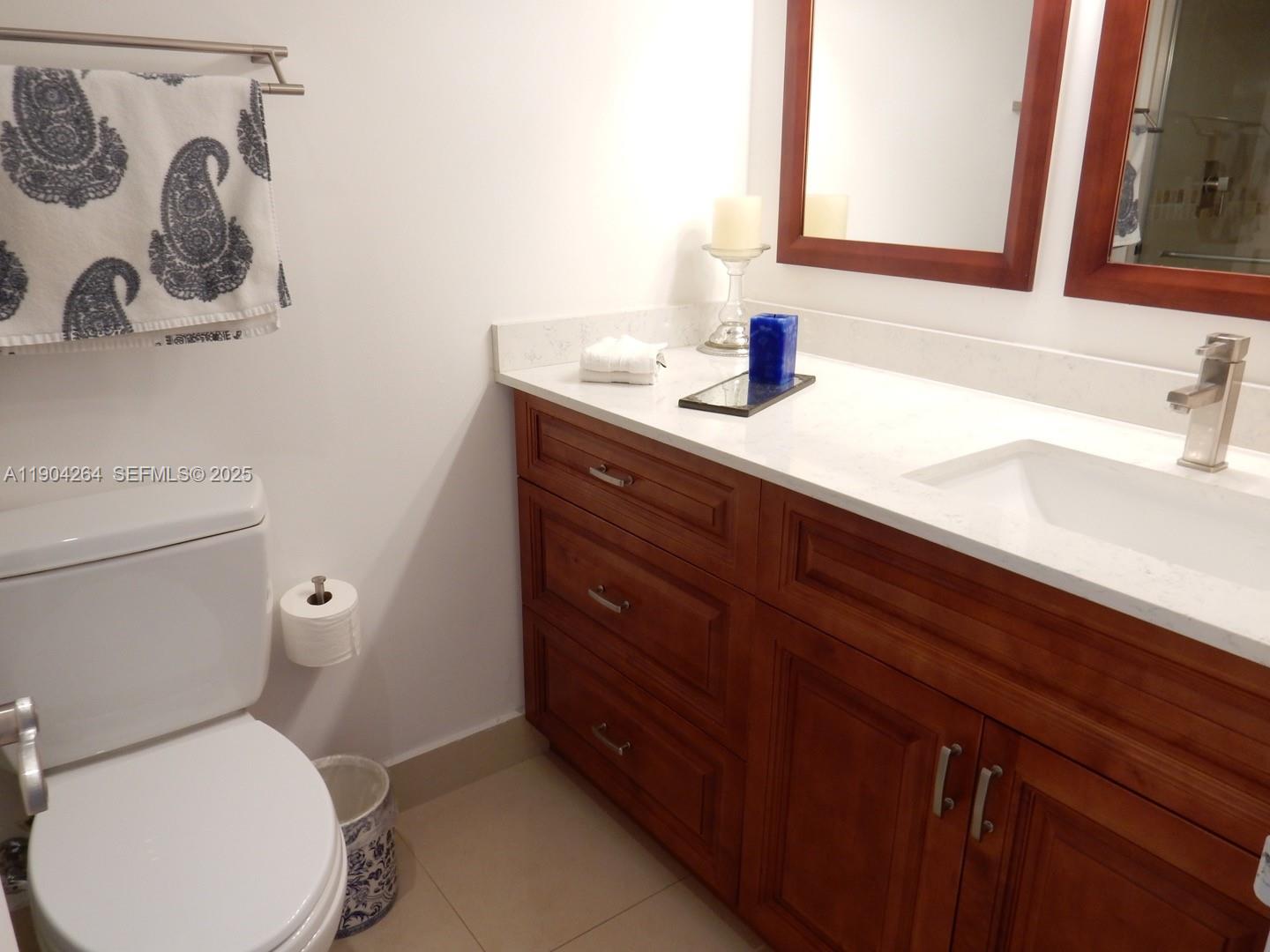 1420 Brickell Bay Drive, Unit 1406D Miami, FL 33131 - Photo 12 of 23 a bathroom with a toilet sink and mirror