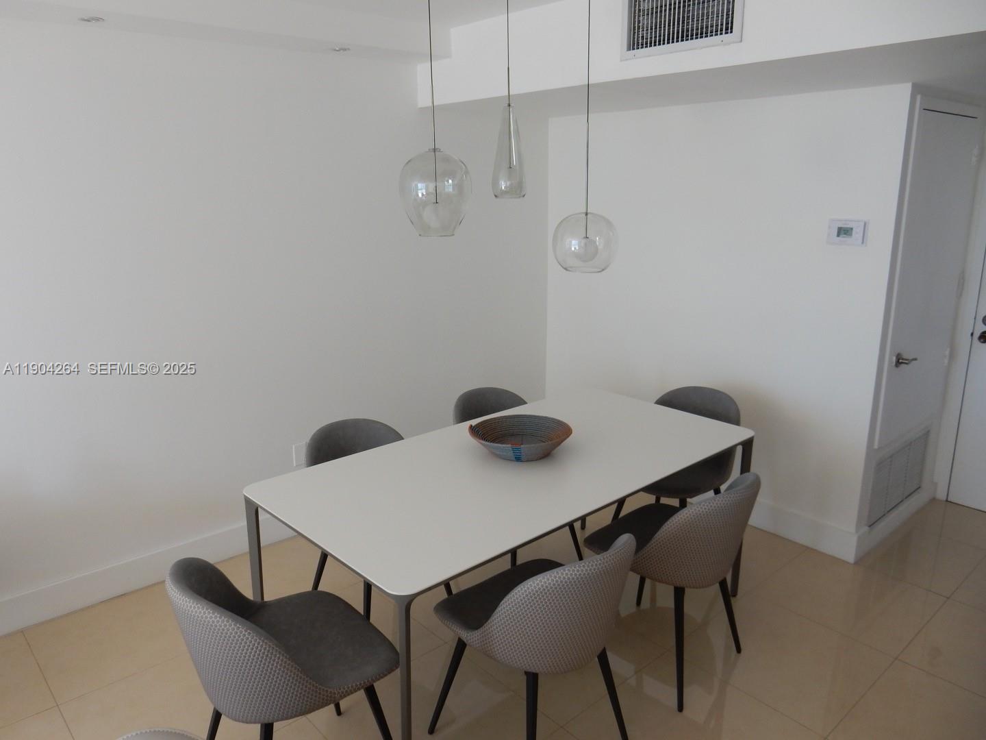 1420 Brickell Bay Drive, Unit 1406D Miami, FL 33131 - Photo 14 of 23 a view of a dining room with furniture and wooden floor