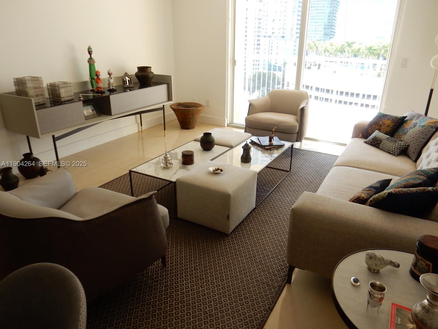 1420 Brickell Bay Drive, Unit 1406D Miami, FL 33131 - Photo 15 of 23 a living room with furniture and floor to ceiling windows