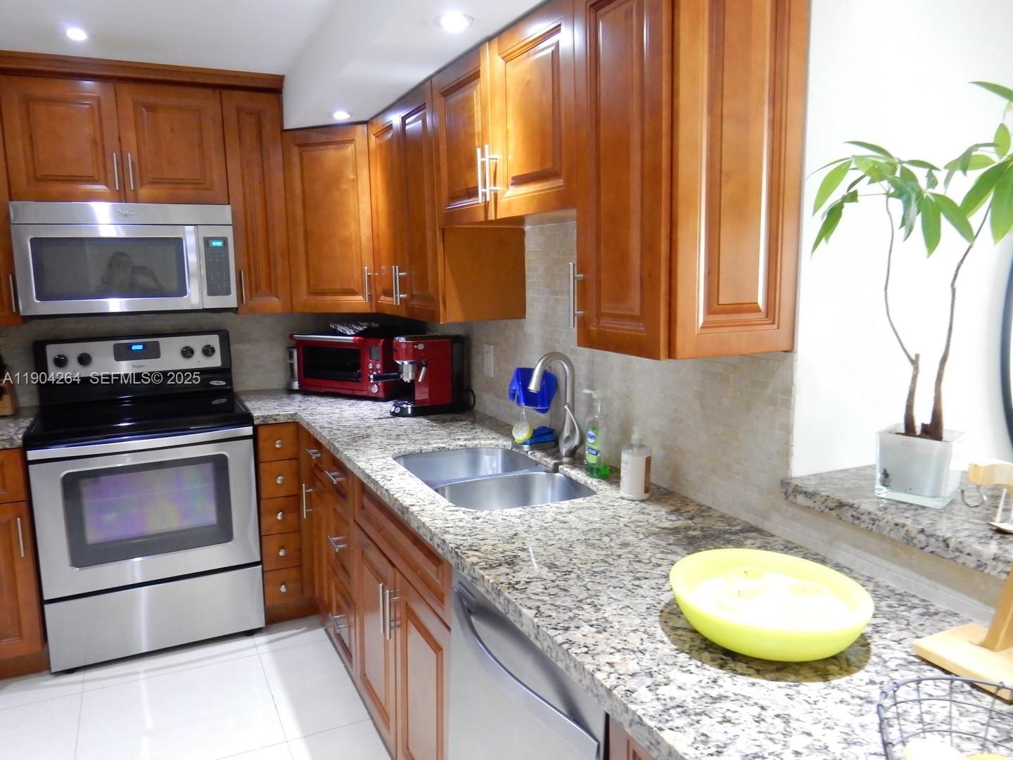 1420 Brickell Bay Drive, Unit 1406D Miami, FL 33131 - Photo 6 of 23 a kitchen with a sink stove and microwave