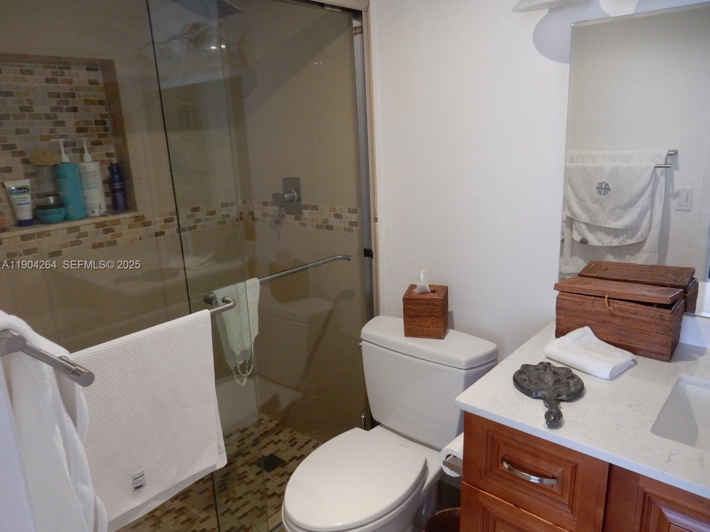 1420 Brickell Bay Drive, Unit 1406D Miami, FL 33131 - Photo 9 of 23 a bathroom with a toilet a sink and mirror