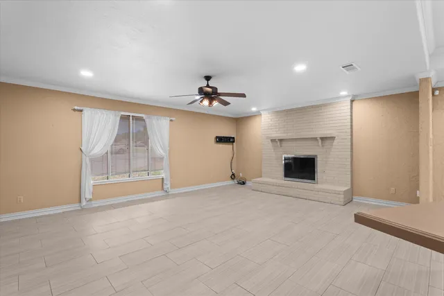 a view of an empty room with a fireplace and a window