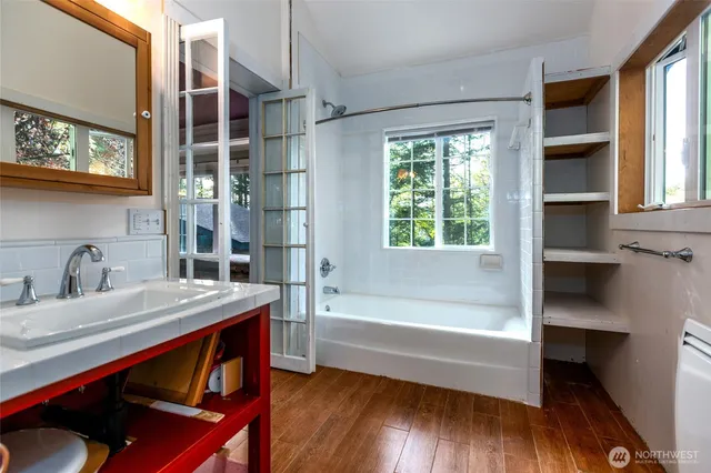 a bathroom with a sink a bathtub and a window