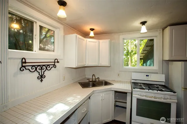 a kitchen with a stove a sink and a window