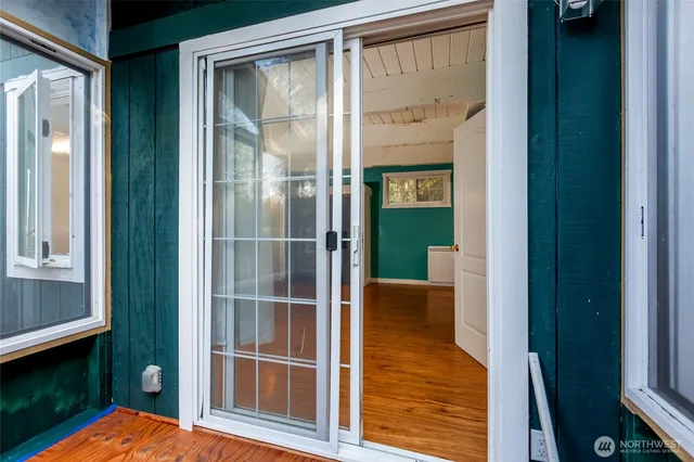 a view of hallway with a large window and wooden floor