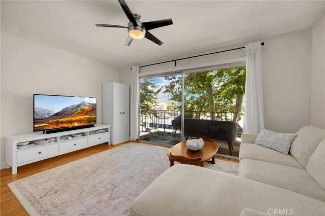 a living room with furniture flat screen tv and a large window