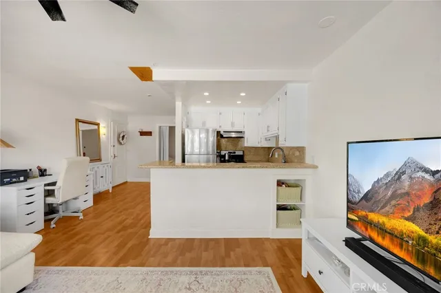 a living room with stainless steel appliances kitchen island granite countertop furniture and a couch