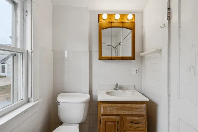a bathroom with a toilet sink and mirror