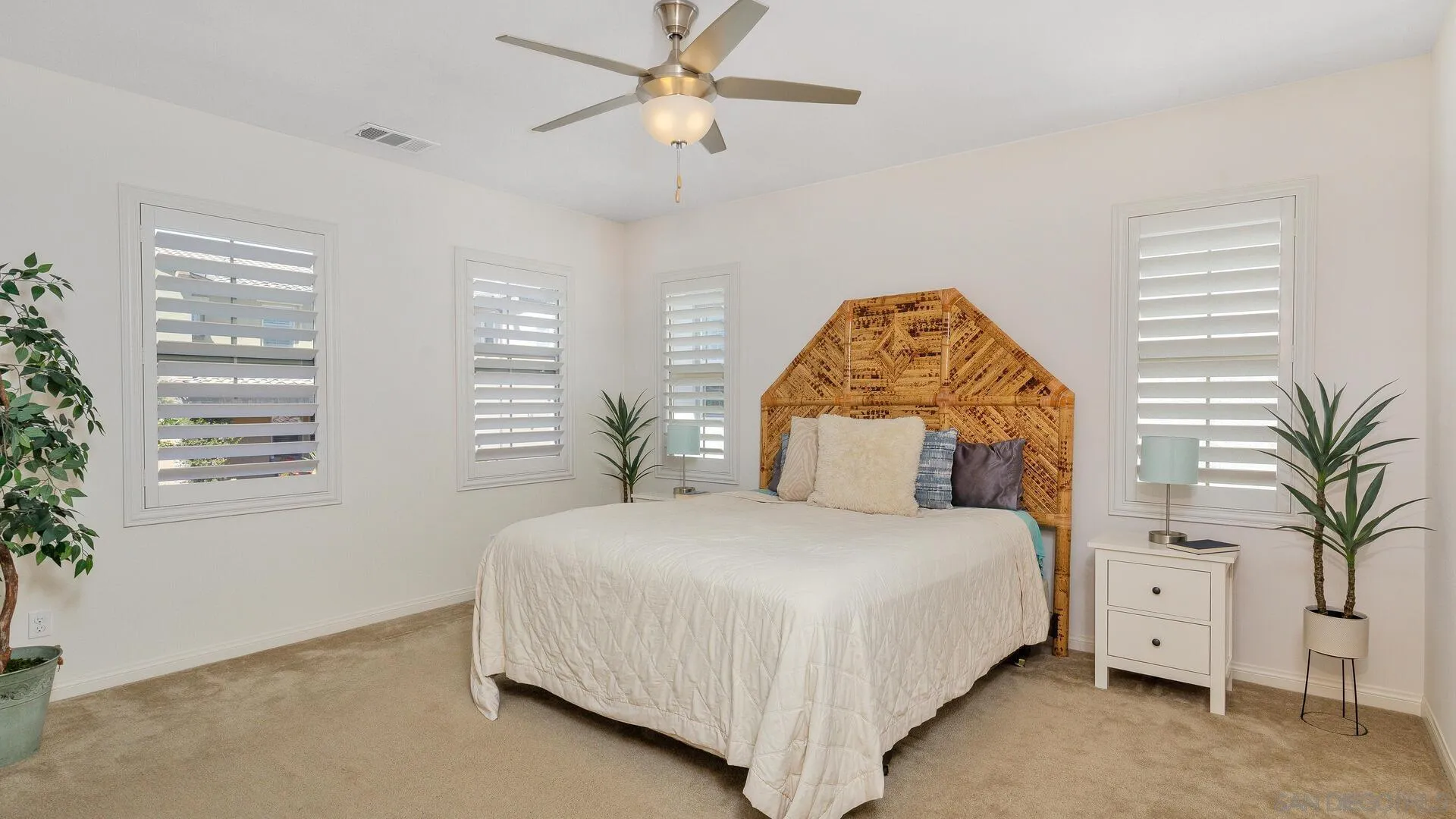 15575 Tanner Ridge Road San Diego, CA 92127 - Photo 13 of 41 a bedroom with a large bed and a chandelier
