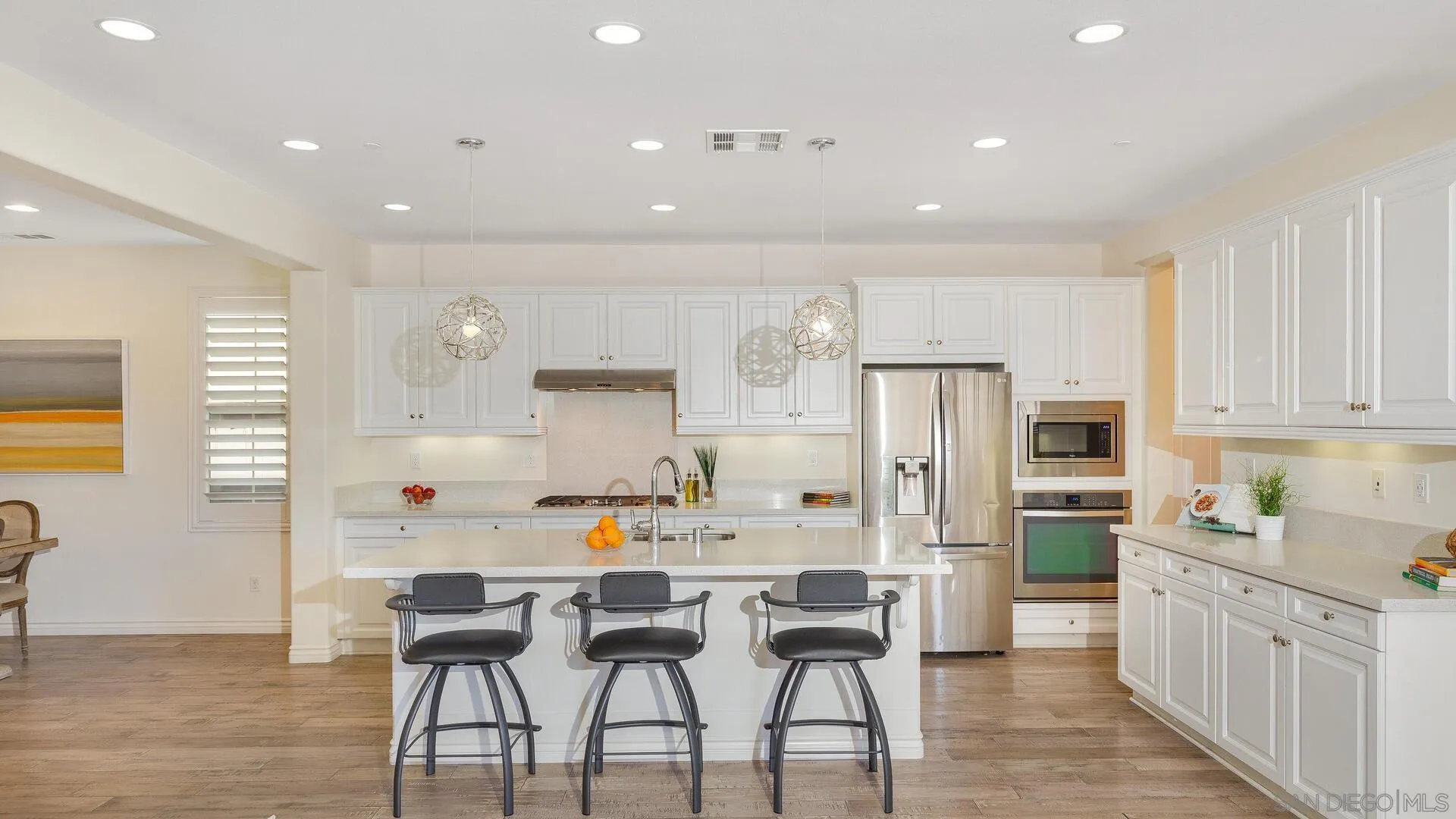 15575 Tanner Ridge Road San Diego, CA 92127 - Photo 2 of 41 a kitchen with stainless steel appliances a refrigerator a stove a sink dishwasher and a dining table with wooden floor
