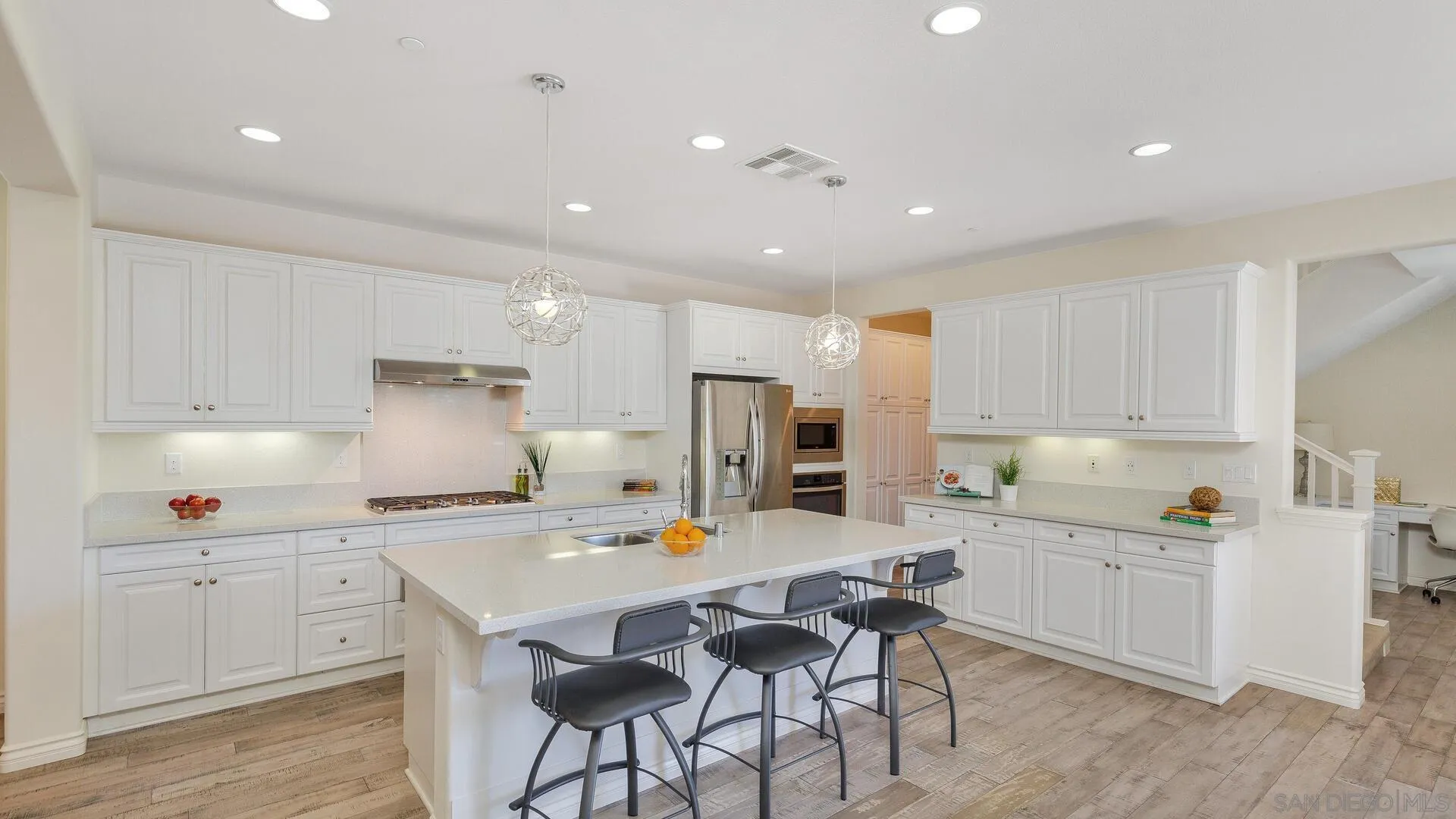 15575 Tanner Ridge Road San Diego, CA 92127 - Photo 3 of 41 a kitchen with a sink white cabinets and stainless steel appliances