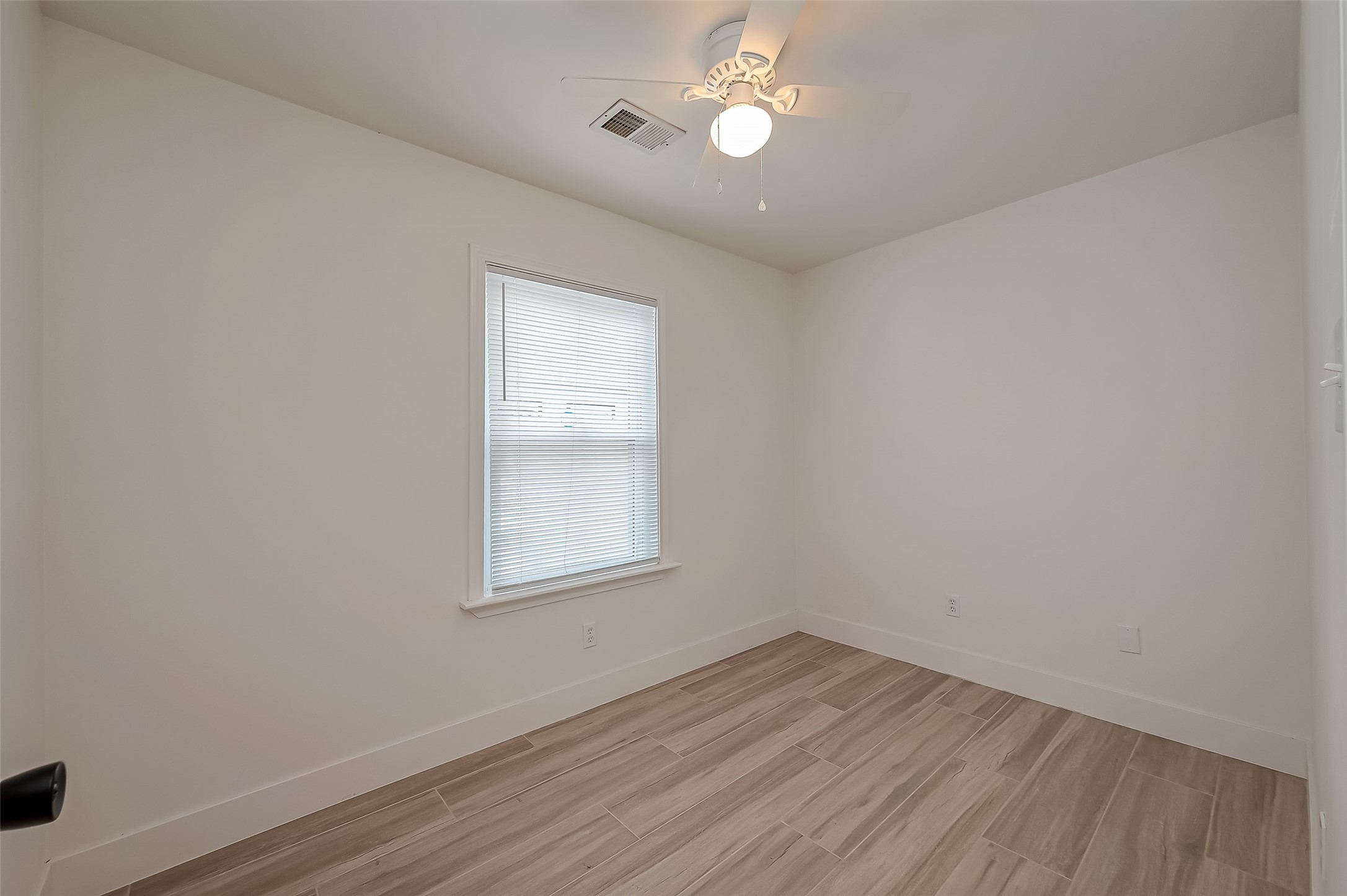 915 Adele Street Houston, TX 77009 - Photo 16 of 23 an empty room with wooden floor and windows