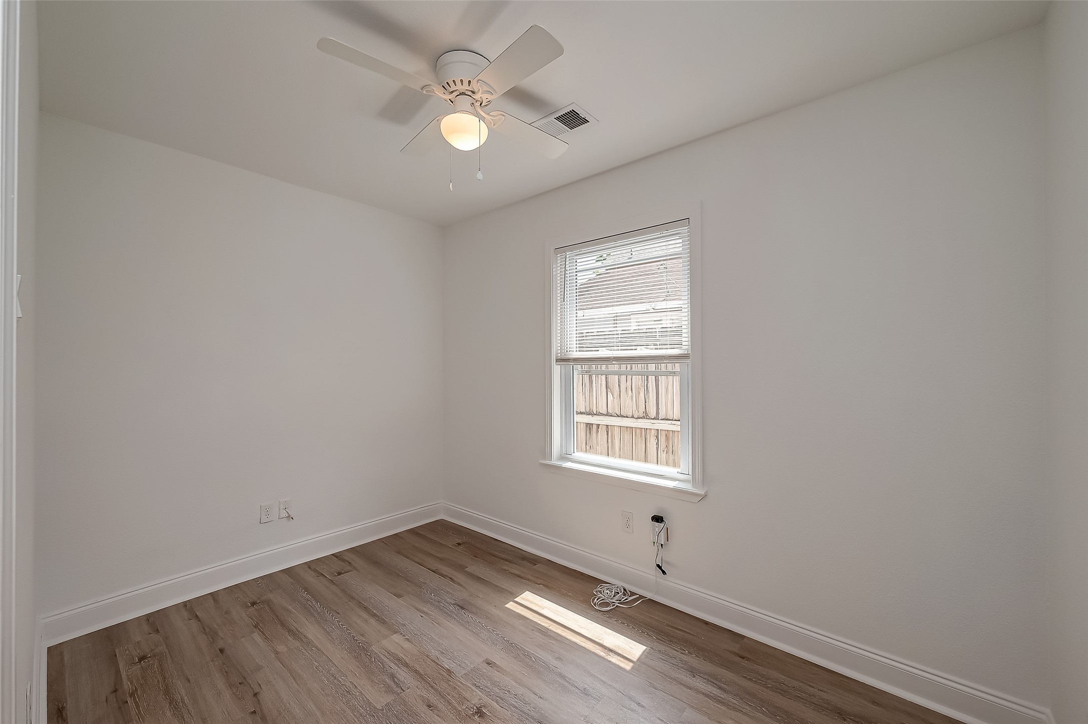 915 Adele Street Houston, TX 77009 - Photo 18 of 23 an empty room with wooden floor and windows