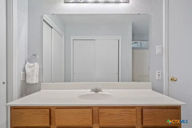 a bathroom with a granite countertop sink and a mirror