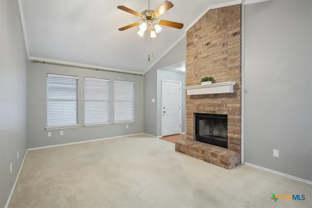 an empty room with windows and fireplace