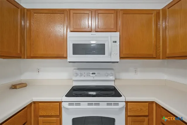 a kitchen with granite countertop cabinets stainless steel appliances and wooden cabinets