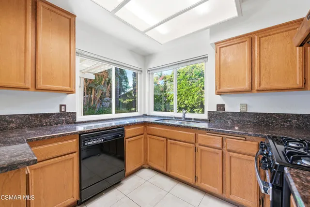 a kitchen with granite countertop cabinets sink and white appliances