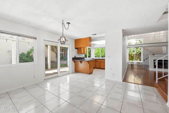 a open kitchen with stainless steel appliances granite countertop a refrigerator a sink a stove top oven and a large window