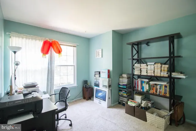 a living room with furniture a bookshelf and a window