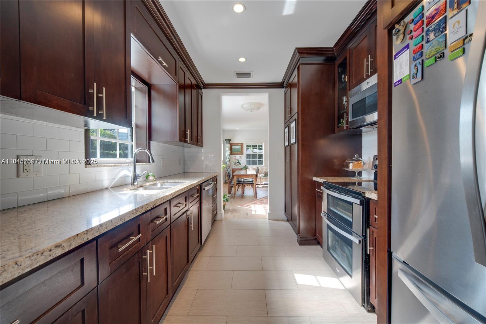 106 Florida Avenue Coral Gables, FL 33133 - Photo 11 of 34 a kitchen with stainless steel appliances granite countertop a refrigerator and a sink