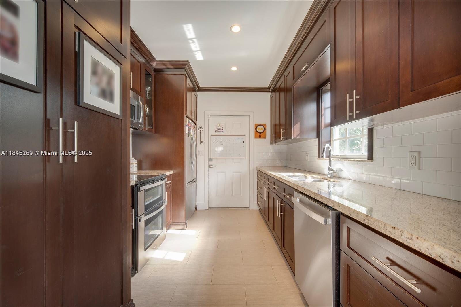 106 Florida Avenue Coral Gables, FL 33133 - Photo 10 of 34 a kitchen with stainless steel appliances granite countertop a sink and a refrigerator