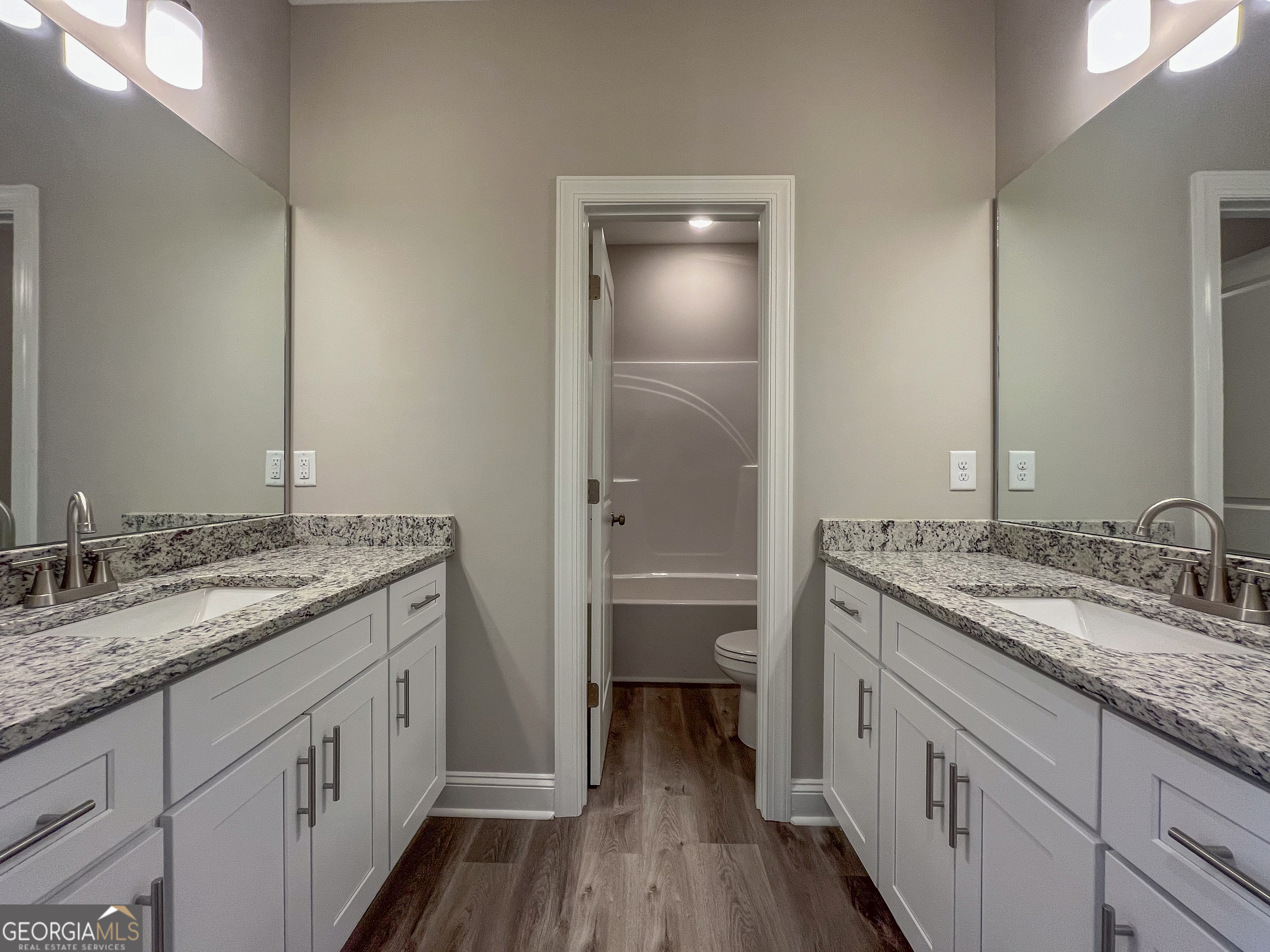 711 Flanders Lane Dublin, GA 31021 - Photo 34 of 49 a bathroom with a granite countertop sink a toilet and a large mirror
