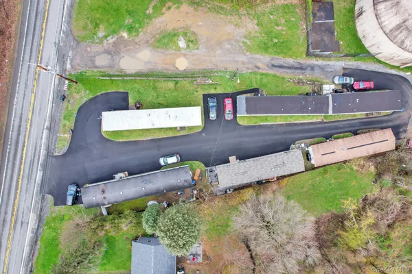 an aerial view of a house with a yard and a large tree