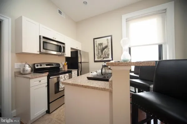 a kitchen with stainless steel appliances a refrigerator and a stove top oven