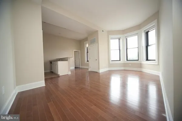 a kitchen with white cabinets and wooden floor