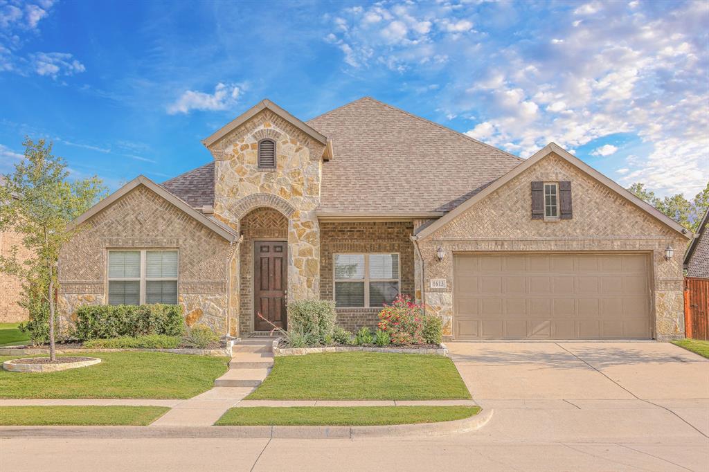 1613 Indigo Trail Allen, TX 75002 - Photo 1 of 1 French country inspired facade with brick siding, driveway, a front yard, and a shingled roof