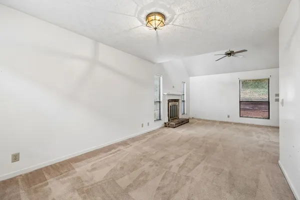 an empty room with a ceiling fan and window