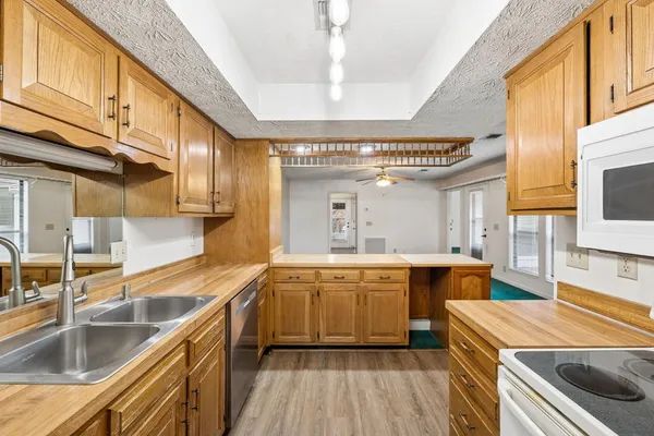 a large kitchen with stainless steel appliances granite countertop a sink and dishwasher a oven with wooden cabinets