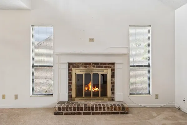 a living room with fireplace furniture and a window