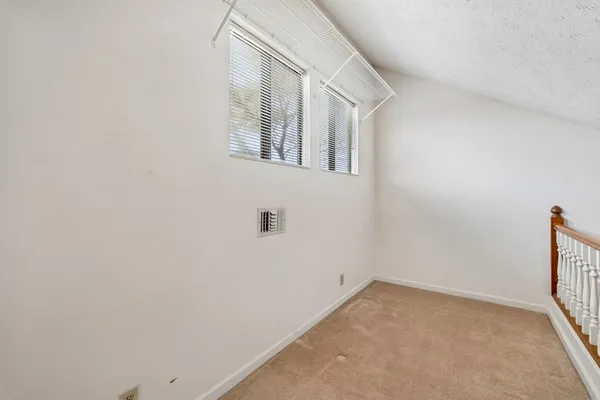 an empty room with a ceiling fan and window
