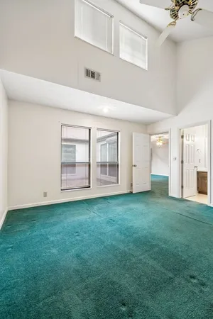 a view of an empty room with window and fan